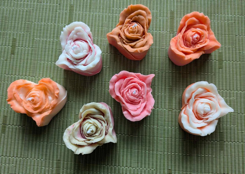 Sept bougies rose cœur multicolores vues de dessus sur un set de table vert