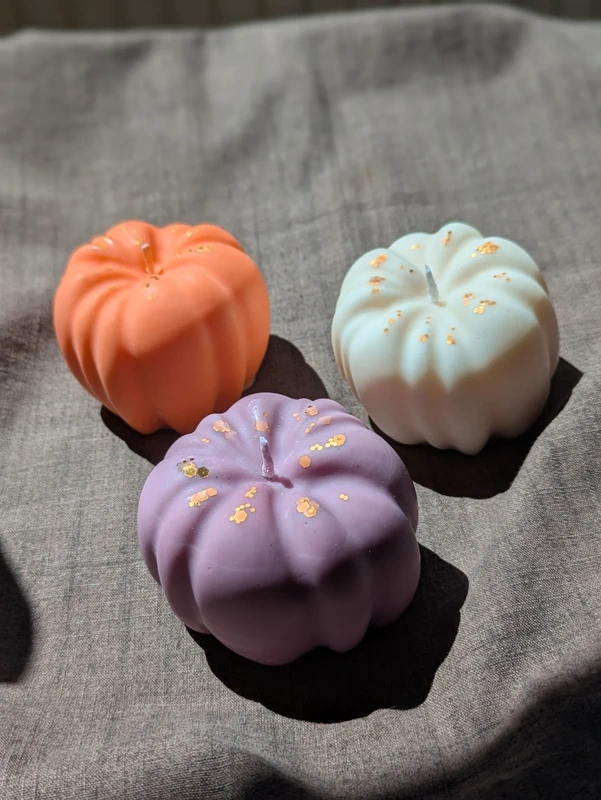 Bougies citrouilles pastel vues de dessus sur textile