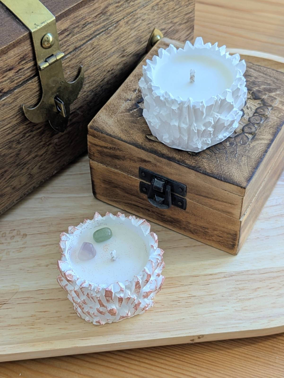 Bougie cristal blanche sur un coffret en bois et bougie rose aux pierres naturelles