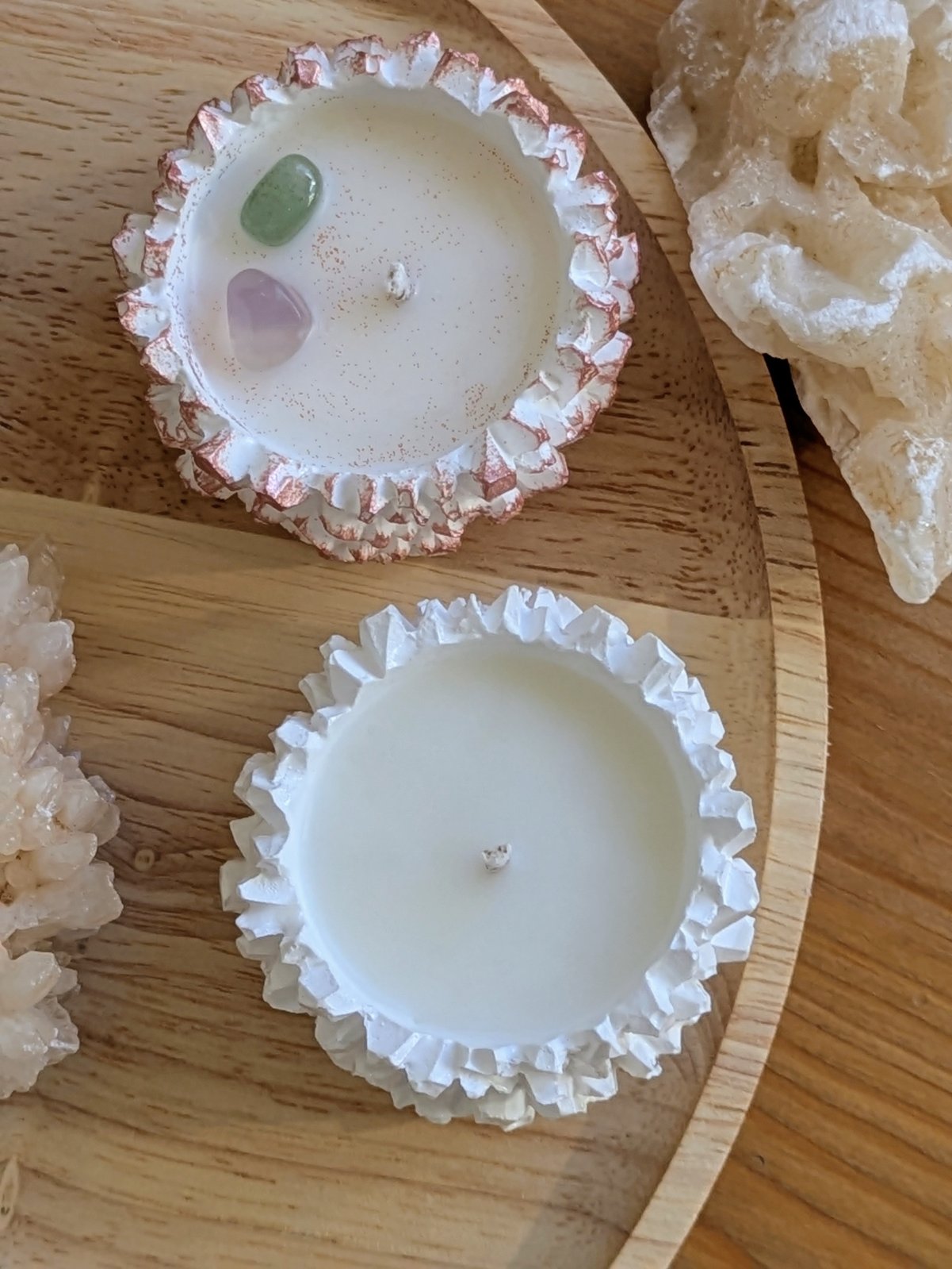 Vue de dessus de deux bougies cristal, pierres lilas et verte sur la cire de soja