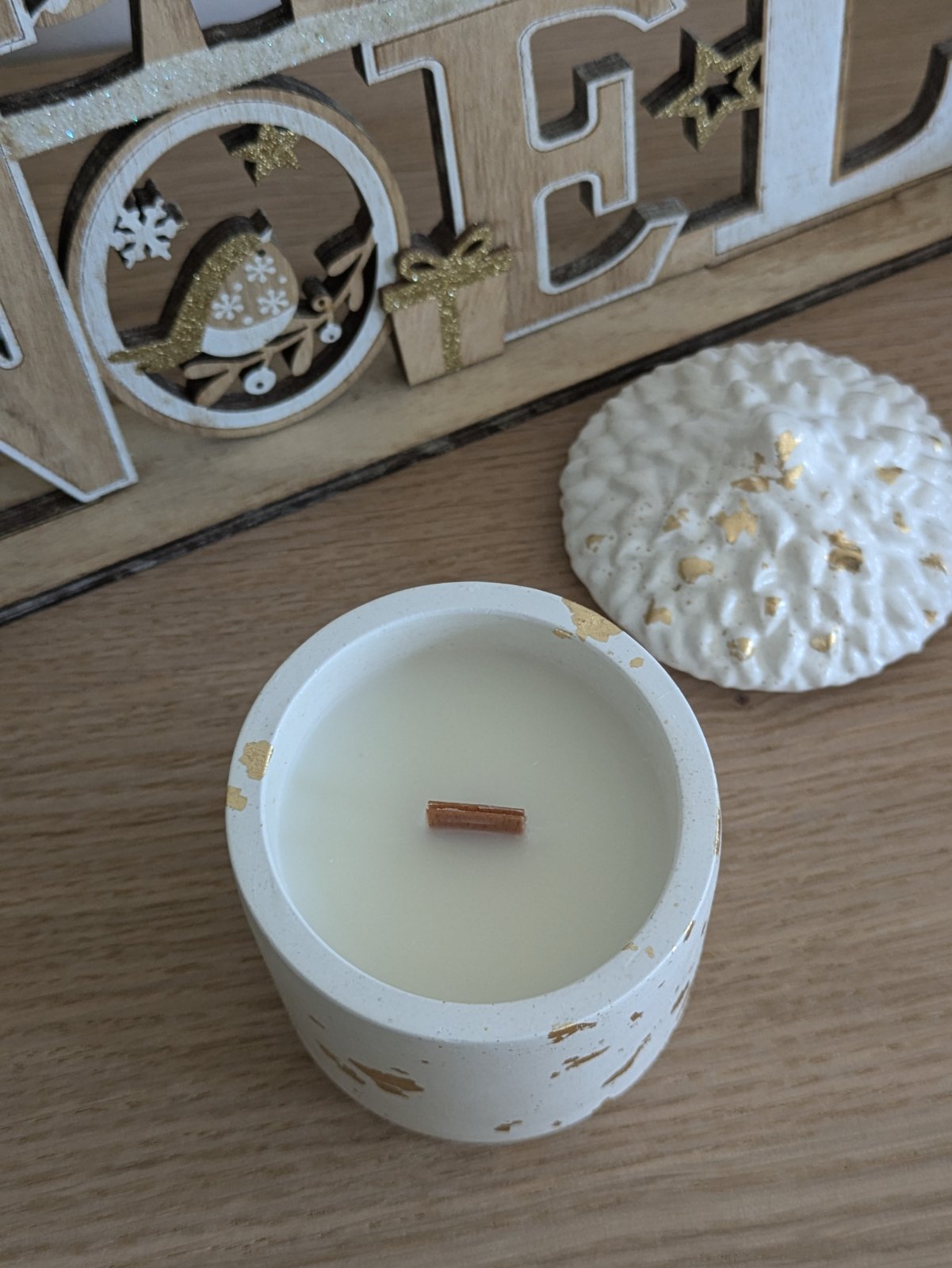 Bougie gland vue de dessus, cire de soja et mèche en bois, devant des lettres Noël