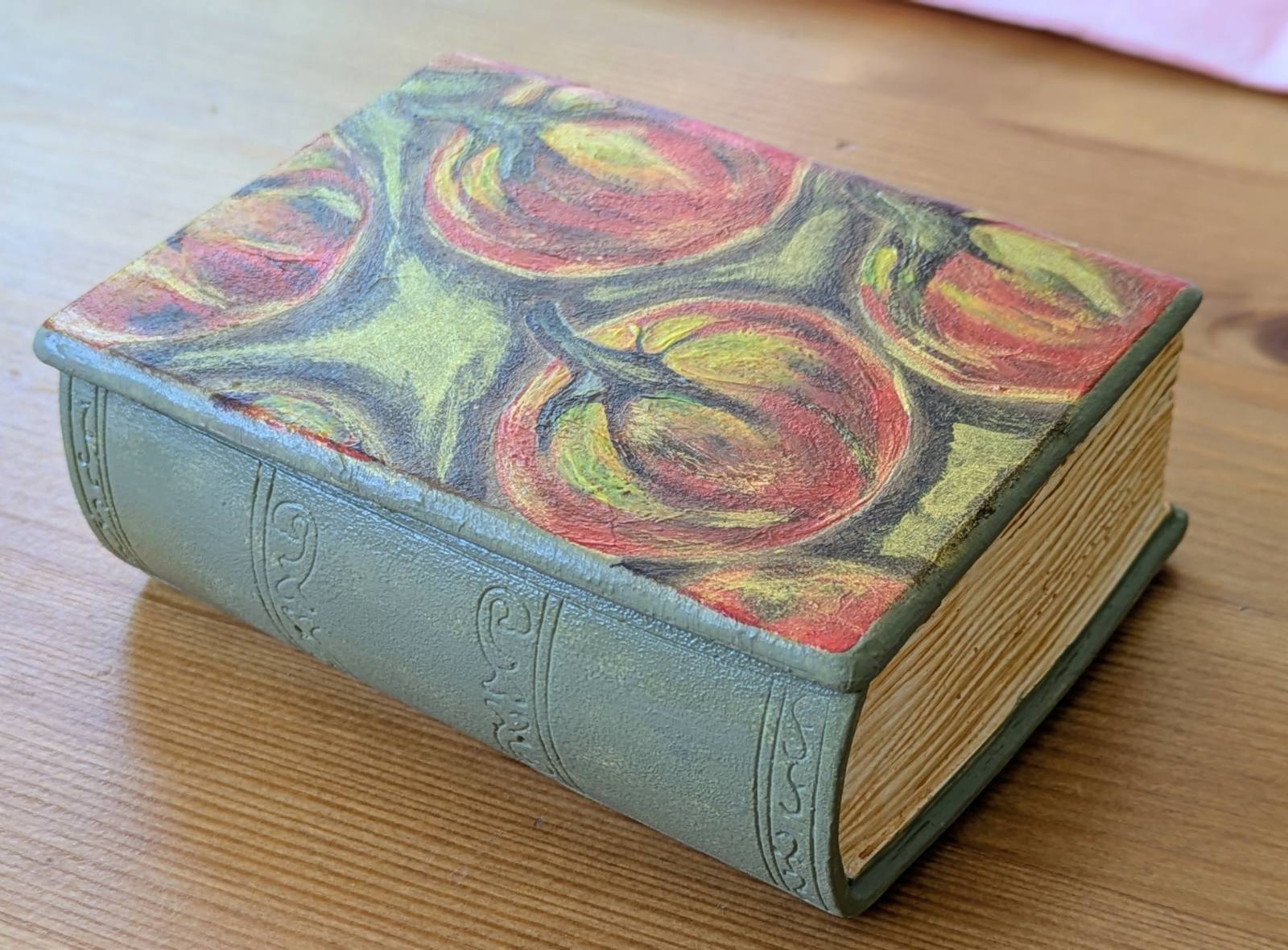 Grande bougie livre fermée, dos vert en relief et citrouilles peintes sur le couvercle