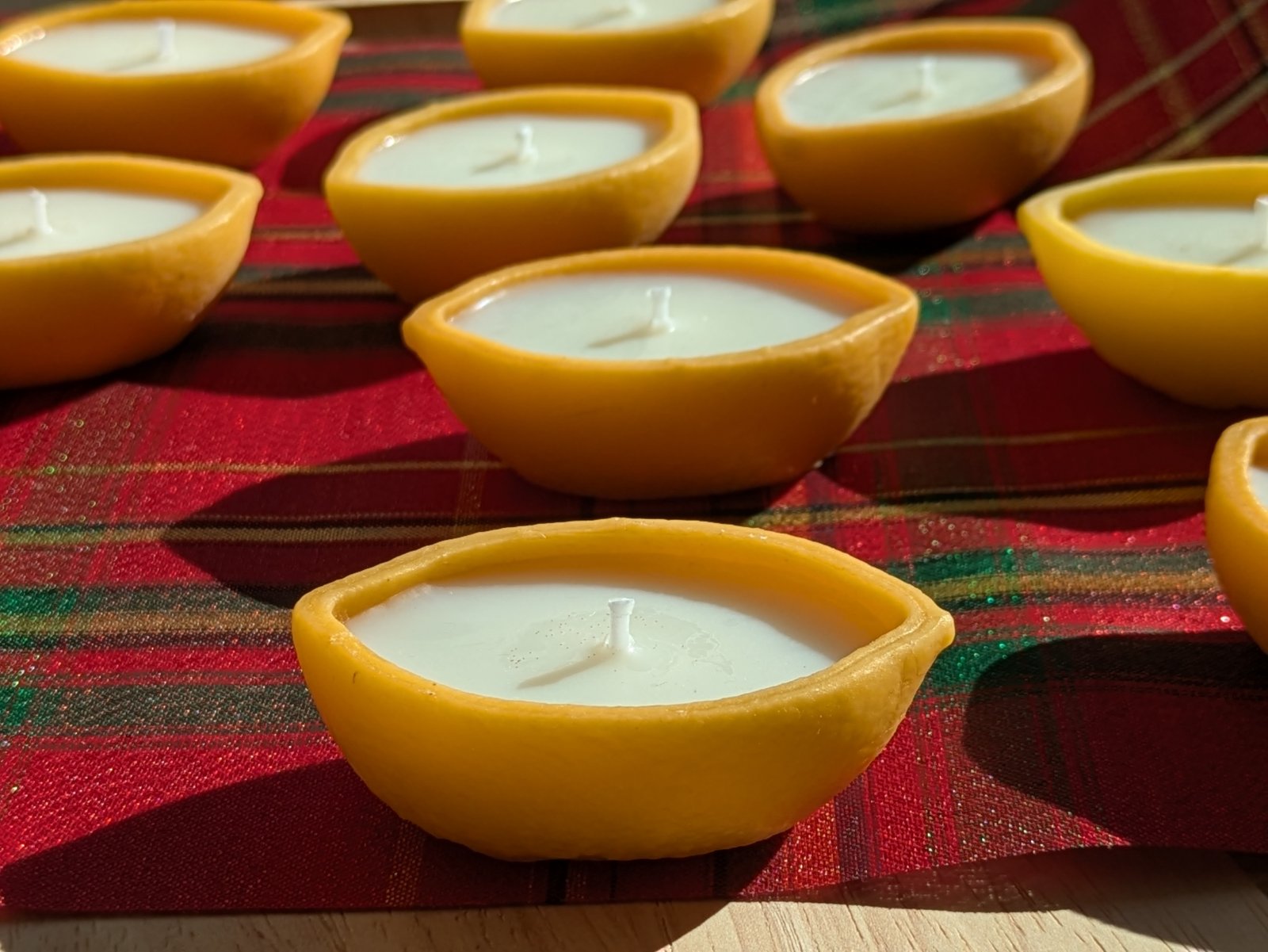 Plusieurs bougies citron alignées sur un tissu écossais, écorce en cire d'abeille