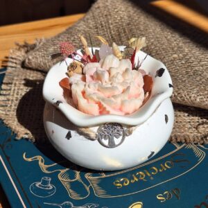 Bougie magie blanche en chaudron de sorcière blanc posée sur un grimoire, MonaLuna Candles