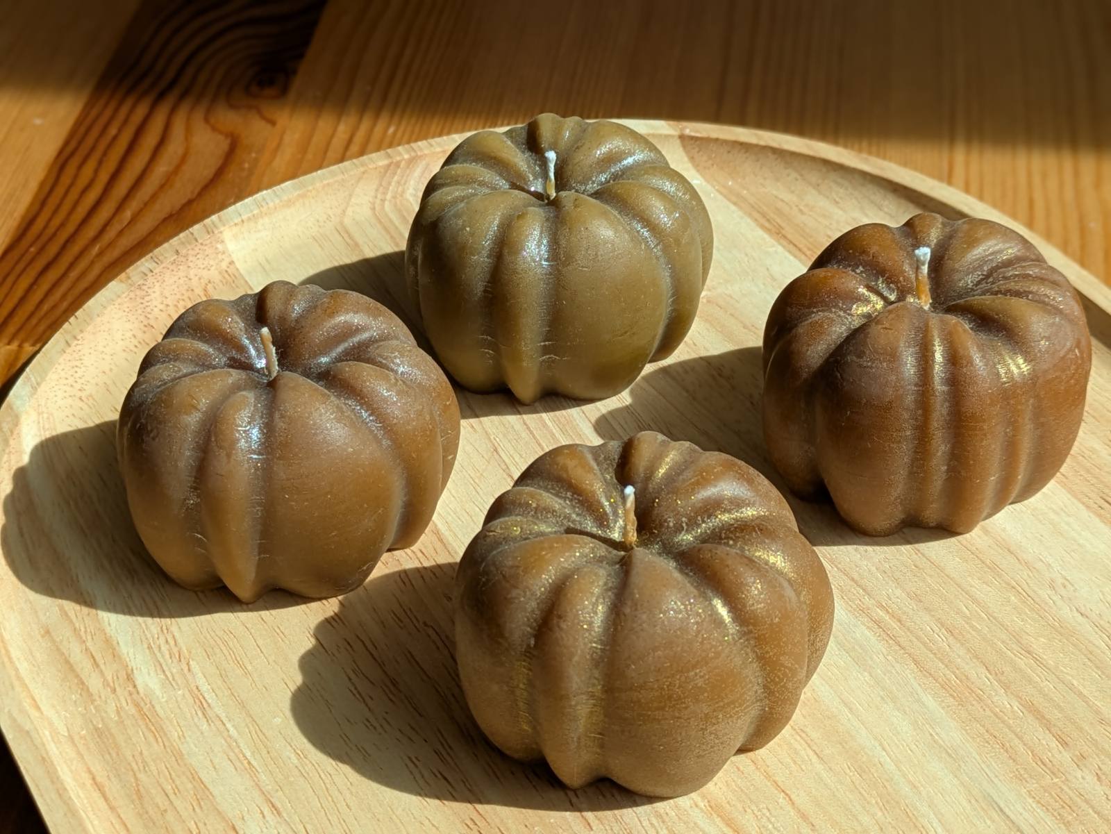 Bougie citrouille en cire d'abeille, quatre pièces poudre dorée et argentée sur un plateau en bois