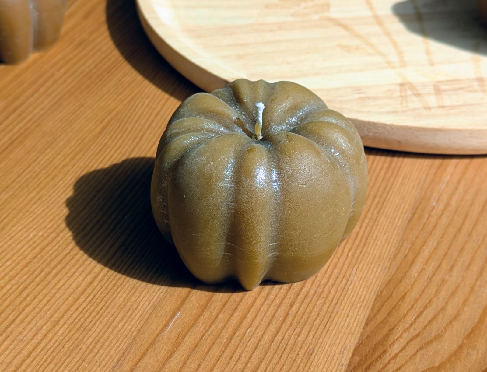 Petite citrouille en cire d'abeille finition argentée posée sur une table en bois