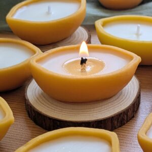 Bougie citron allumée sur une rondelle de bois, poussière dorée visible dans la cire de soja fondue, MonaLuna Candles