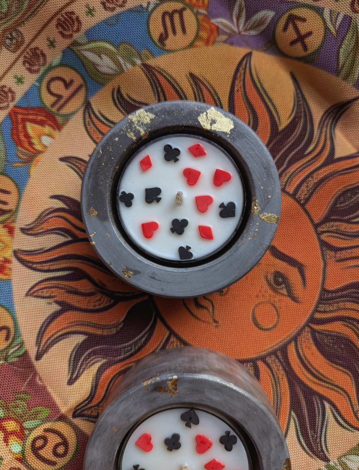 Bougie cartes à jouer de près sur un tissu astrologique, feuilles dorées sur le bougeoir