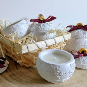 Bougie boule de Noël en plâtre blanc ouverte, couvercles à ruban bordeaux et panier de paille