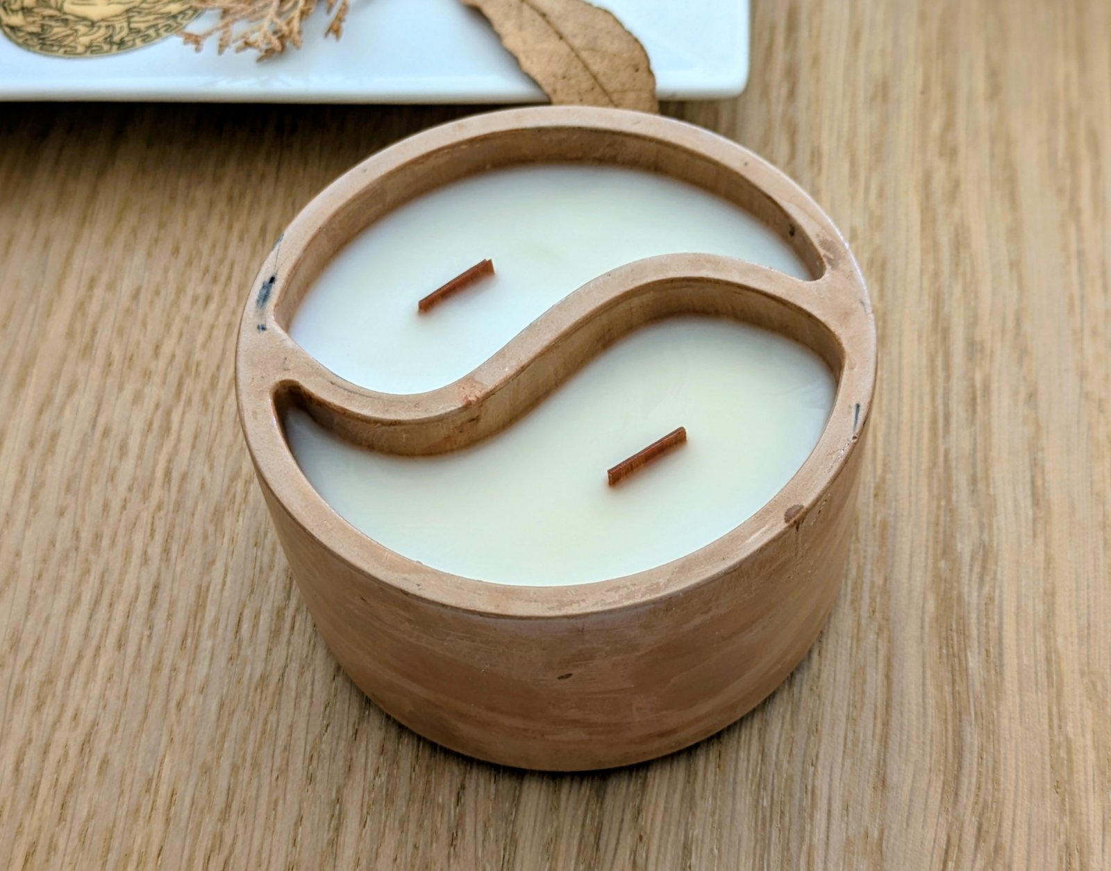 Bougie yin yang en plâtre marbré sur une table en bois, deux mèches en bois