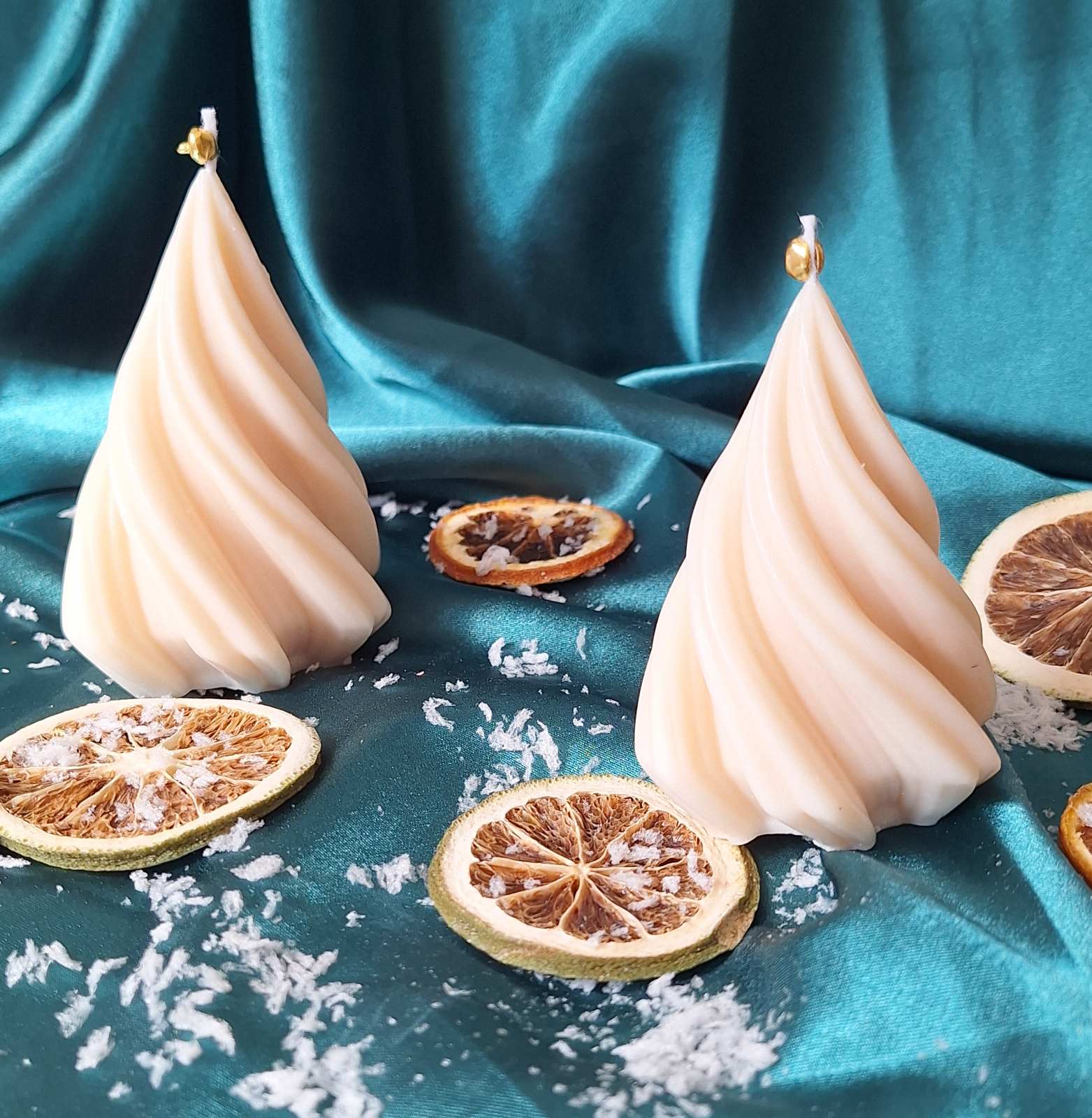 Bougie sapin torsadé de près, torsades en relief et cloche dorée, oranges séchées