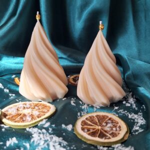 Bougie sapin torsadé en cire de soja crème avec petite cloche dorée, oranges séchées sur tissu satiné