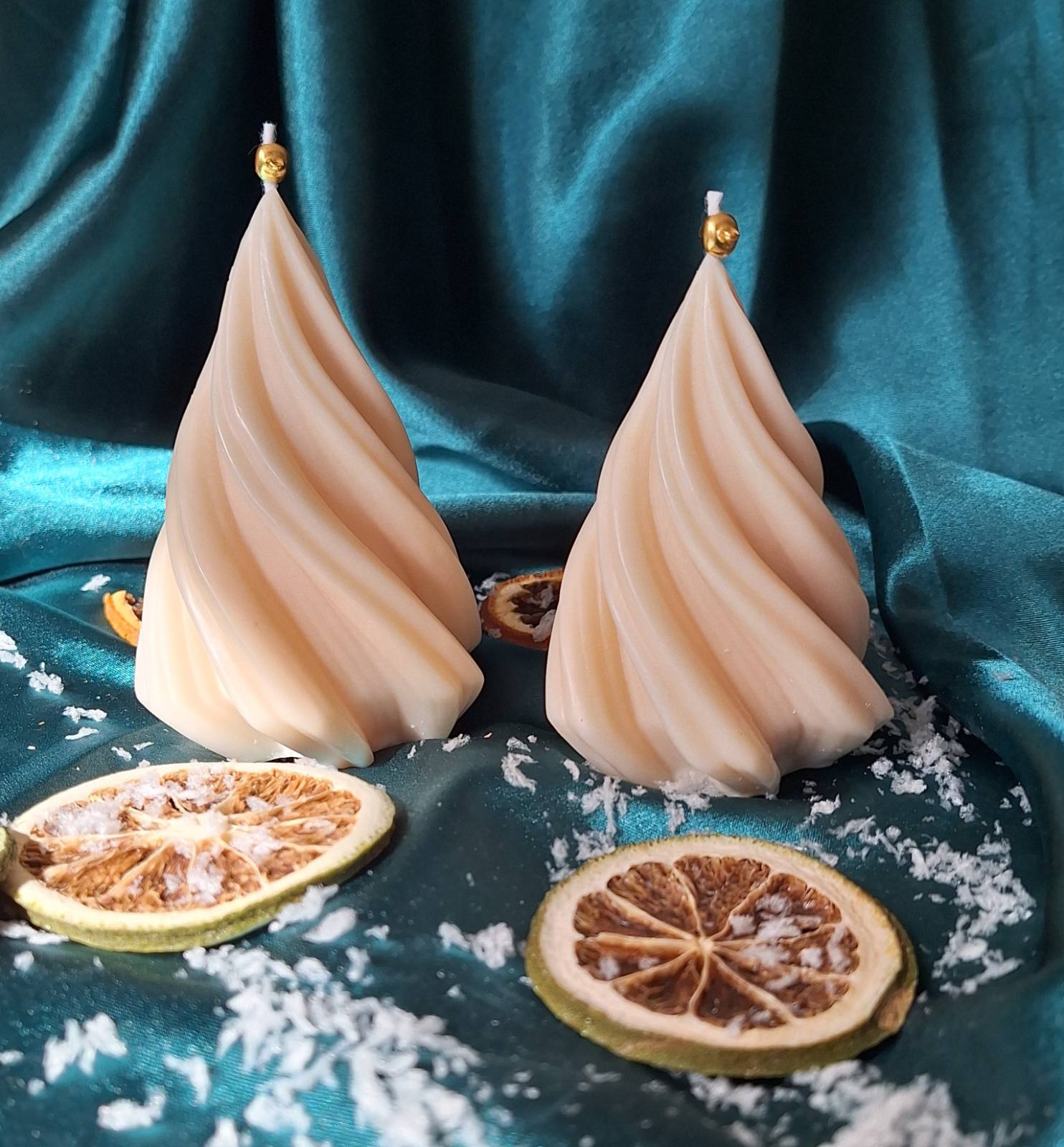 Bougie sapin torsadé en cire de soja crème avec petite cloche dorée, oranges séchées sur tissu satiné